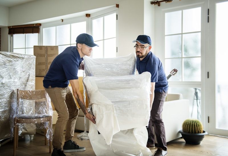 Movers carefully wrapping and carrying furniture in a home